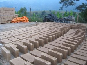 The community casts the adobe bricks used for construction